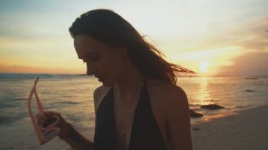 Tropik sahilde günbatımı gülümseyen güzel genç kadın portresi kapatın