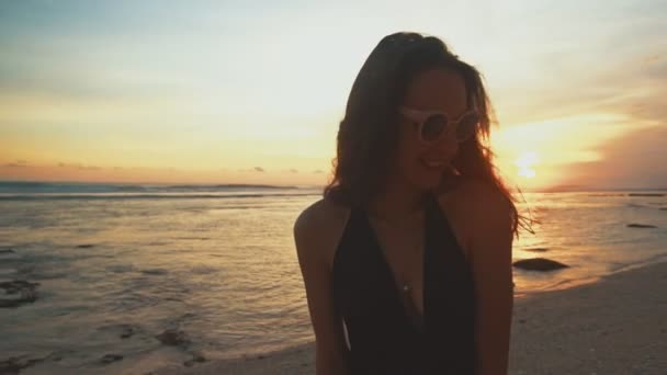 Close-up van portret van mooie jonge vrouw die lacht op tropisch strand bij zonsondergang — Stockvideo