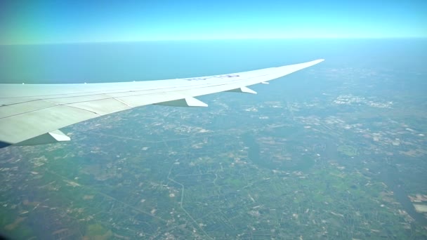 Avion passager en vol. Aile d'avions volant au-dessus de la terre colorée 