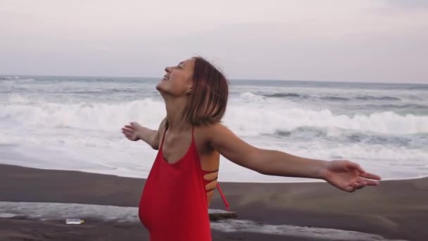 Танцююча вільна щаслива жінка на березі океану. Радісна дівчина щаслива кружляє навколо усміхнених на відкритому повітрі в природі сміється розваги . — стокове відео