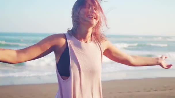 Dans gratis lycklig kvinna på den ocean beach. Glad flicka glad virvlar runt leende utomhus i naturen skrattar ha roligt. — Stockvideo