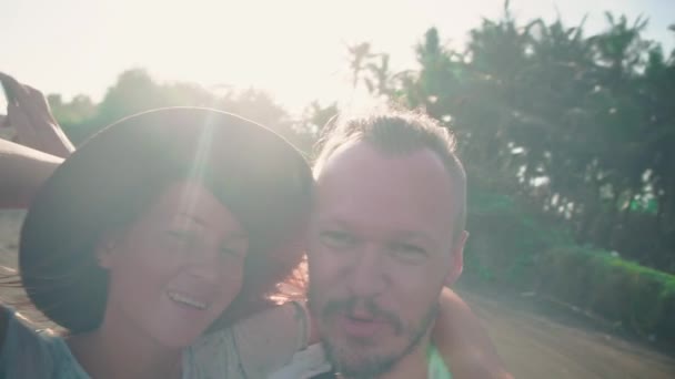 Ρομαντικό ζευγάρι στο φως του ήλιου λήψη selfie βίντεο φωτογραφία πορτραίτου στην παραλία με φωτογραφική μηχανή ή έξυπνο τηλέφωνο. Νεαρό ζευγάρι σε διακοπές απολαμβάνοντας νέες περιπέτειες, χαλάρωση και ταξίδια. — Αρχείο Βίντεο