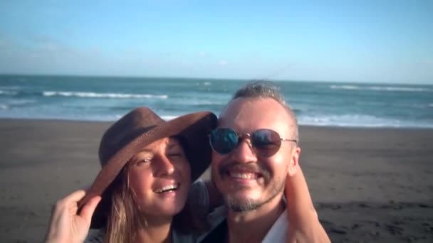 Couple romantique au soleil prenant selfie portrait photo vidéo sur la plage avec caméra ou téléphone intelligent. Jeune couple en vacances profitant de nouvelles aventures, détente et voyage . — Video