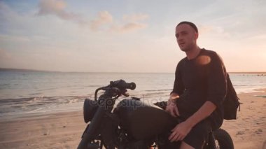 Dolly atış motosikletçi ve gün batımı sırasında yolda onun motosiklet