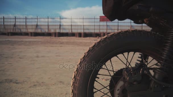 Primer plano dolly disparo de motociclista y su moto en la playa durante el atardecer — Vídeo de stock