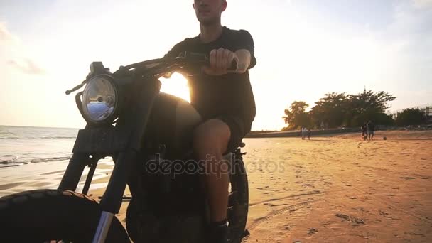 Onun motosiklet sahilde günbatımı sırasında sürüş motosikletçi — Stok video