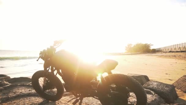 Motocicleta pe plajă în timpul apusului de soare — Videoclip de stoc