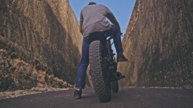 Okyanus plaj iki taş arasında onun motosiklet sürüş motosikletçi