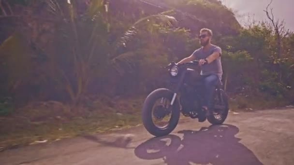 Motocyklista jízdy jeho motorce na ocean beach — Stock video