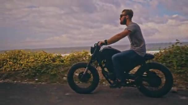 Motociclista dirigindo sua moto na praia do oceano — Vídeo de Stock