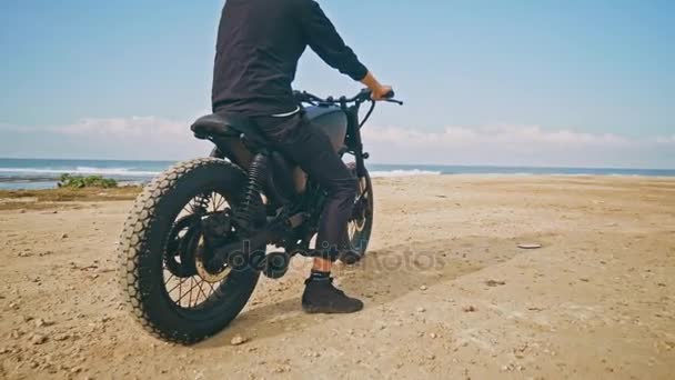 Motorradfahrer fährt mit seinem Motorrad am Strand — Stockvideo