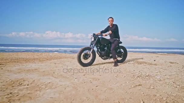 Мотоциклист едет на мотоцикле по пляжу — стоковое видео