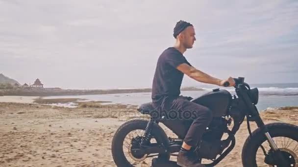 Motorkář řízení jeho motocykl na pláži — Stock video