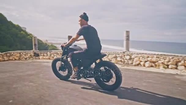 Motociclista dirigindo sua moto na praia do oceano — Vídeo de Stock