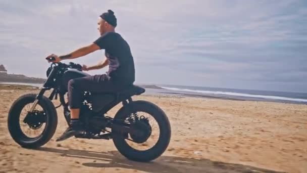 Motociclista conduciendo su moto en la playa — Vídeos de Stock