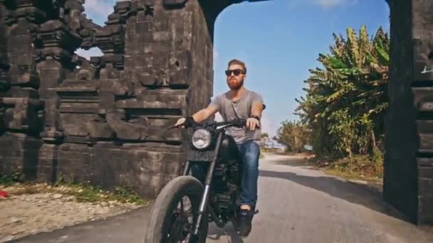 Motociclista conduciendo su moto en la playa del océano — Vídeo de stock