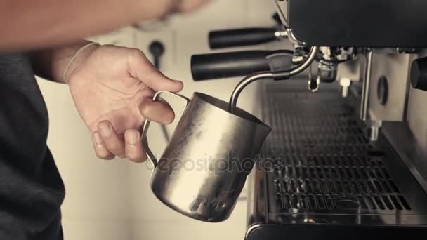 Barista dampfende Milch oder heißer Kakao in einem Edelstahlbecher auf einer industriellen Espressomaschine — Stockvideo