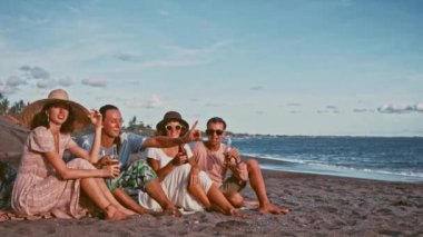 Rahatlatıcı kumsalda gün batımında eğleniyor arkadaş grubu