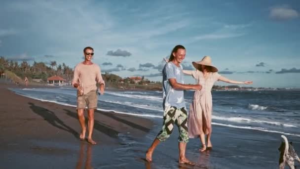 Grupp av vänner har roligt avkopplande på stranden vid solnedgången — Stockvideo