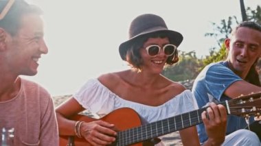 Gençler kumsalda eğleniyor. Hafta sonu adada. Şirket ile bir gitar kamp ateşi etrafında şarkı arkadaş eğlenceli. Sahilde piknik. Gençlik kampanya