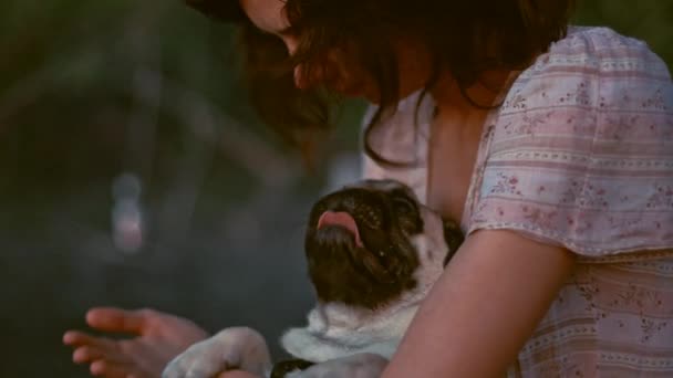 Young woman playing with her dog. Sitting on the beach at sunset. Summer vacation — Stock Video