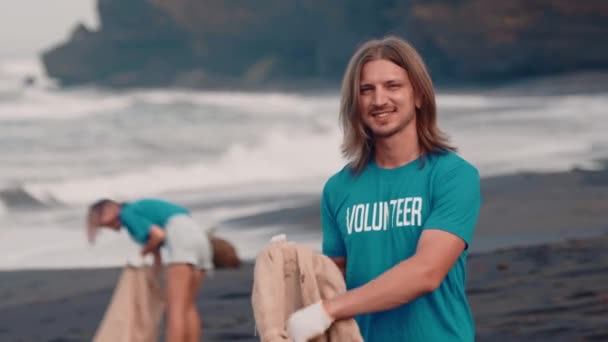 Volontaire met une bouteille en plastique dans un sac écologique, met dans rendre la planète meilleure — Video