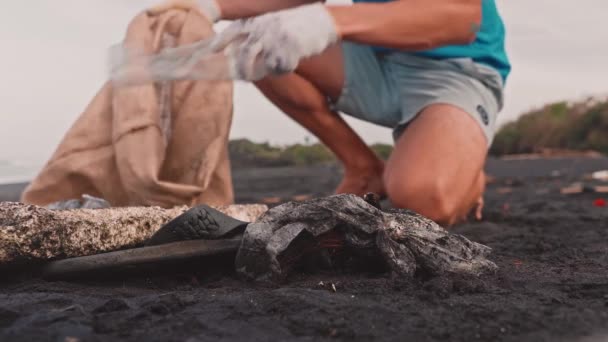 Close up de voluntários sentar e pegar lixo na praia — Vídeo de Stock