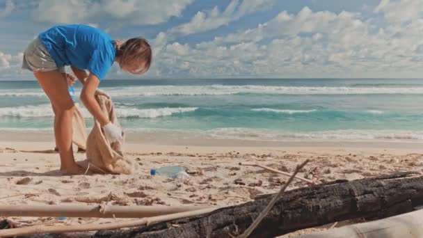 Dos voluntarios recogen basura intro basura eco playa en la costa — Vídeos de Stock