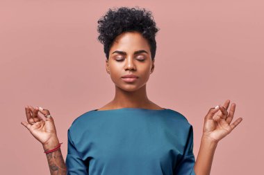 Sakin bir kadın meditasyon yapıyor, iş kavramında stres yok, düşünceli barışçıl genç iş kadını ya da doktor bej arka planda izole edilmiş solunum egzersizleri yapıyor..