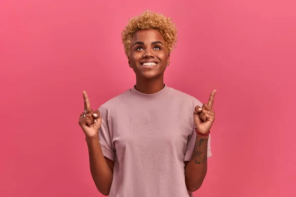 Drôle positif mixte race fille en rose chemise pointe ses doigts vers le haut — Photo