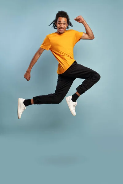 Hombre afroamericano saltando alto y feliz afortunado jovencito que se divierte. — Foto de Stock