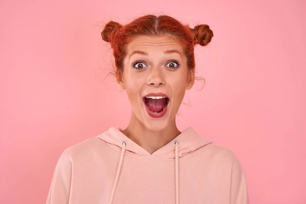 Retrato de uma menina caucasiana de cabelos vermelhos alegre emocional gritando em loucura com sensação de alegria estática excessiva isolado sobre fundo rosa. Conceito especial de ofertas e vendas na loja online — Fotografia de Stock