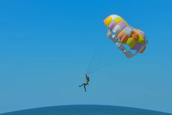 A man is flying on a parachute over the sea — Stock Photo, Image