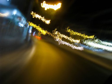 Karanlık bir gecede bulanık yol hareketi - karanlık bir gecede yolun çok sallantılı uzun pozlama resmi - soyut uzun gece pozlama yolu