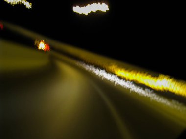 Karanlık bir gecede bulanık yol hareketi - karanlık bir gecede yolun çok sallantılı uzun pozlama resmi - soyut uzun gece pozlama yolu