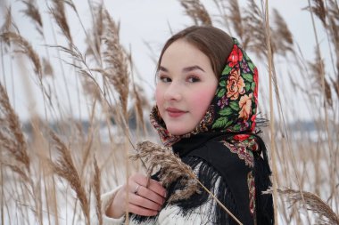 Beyaz kazaklı bir kızın portresi ve doğanın arka planında açık iş şalı.