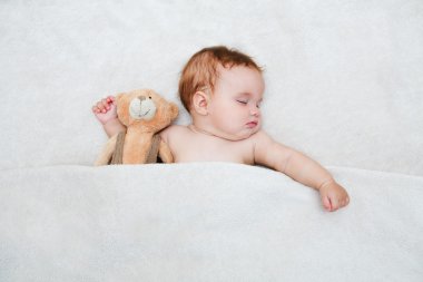 Bebek yatakta yatıyordu. Bebek oyuncak ayı, yeni ailesinden ve aşk kavramı ile uyku.