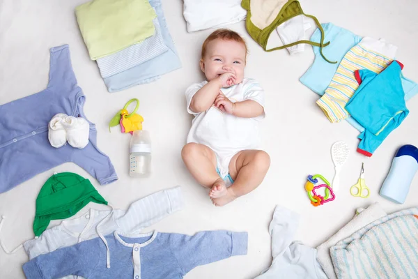 Bebé sobre fondo blanco con ropa, artículos de tocador, juguetes y accesorios para el cuidado de la salud. Lista de deseos o descripción general de compras para el embarazo y la ducha del bebé . —  Fotos de Stock