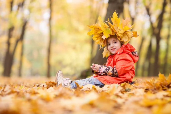 Aranyos kis lány a koszorú, a levelek, a szépség park — Stock Fotó