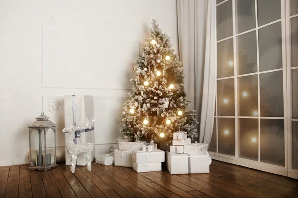 İçinde Noel ağacı ve süslemeleri olan bir oturma odası..
