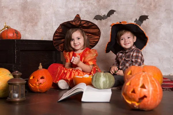 男の子と女の子身に着けていますハロウィン衣装とともにカボチャで家 — ストック写真