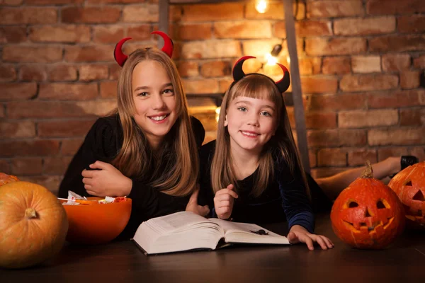 Children in halloween costumes show funny faces