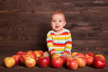 Ahşap arka plan üzerinde kırmızı elma ile sevimli çocuk