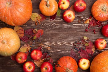 Şükran günü arka plan ile elma, kabak ve ahşap zemin üzerine düşen yapraklar. Sonbahar arka plan