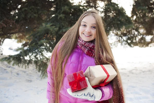 La joven mujer bastante sonriente con un regalo de Navidad al aire libre. x-mas, invierno, concepto de felicidad . —  Fotos de Stock