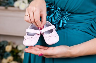 Annenin holding pembe ayakkabı yeni doğan kız için eller