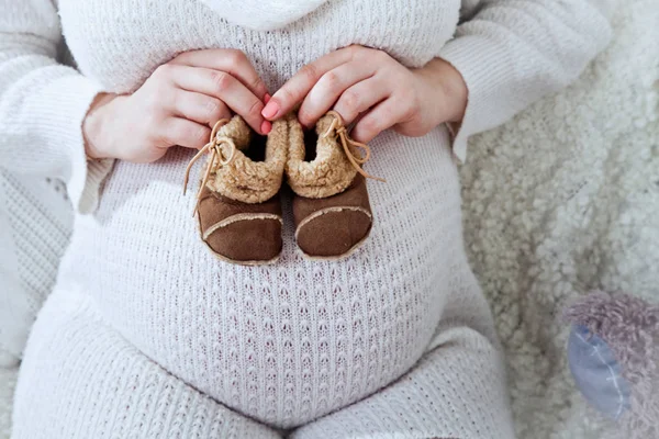 Belly Pregnant Woman White Sweater Mother Hands Holding Shoes Newborn — Stock Photo, Image