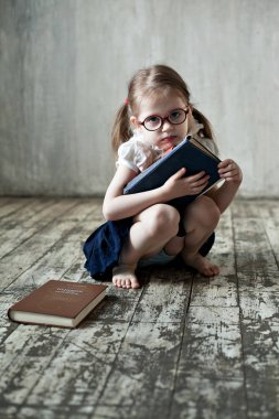 Kitapları olan, gözlüklü küçük bir kız.