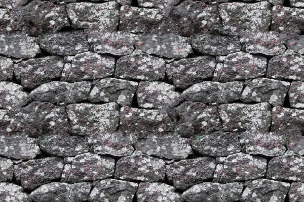 seamless texture. stone wall made of boulders of granite.
