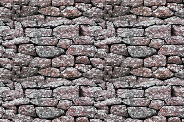 seamless texture. stone wall made of boulders of granite.
